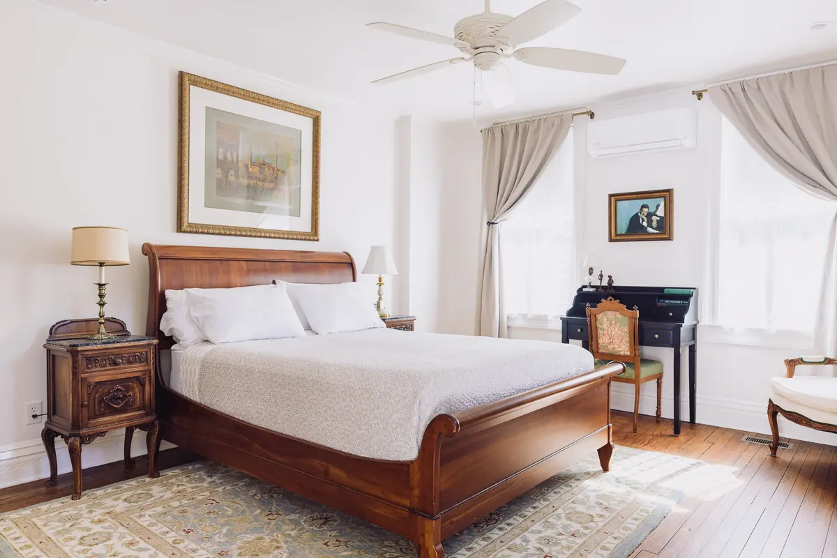 Austen Room queen sleigh bed with antique nightstands and natural light