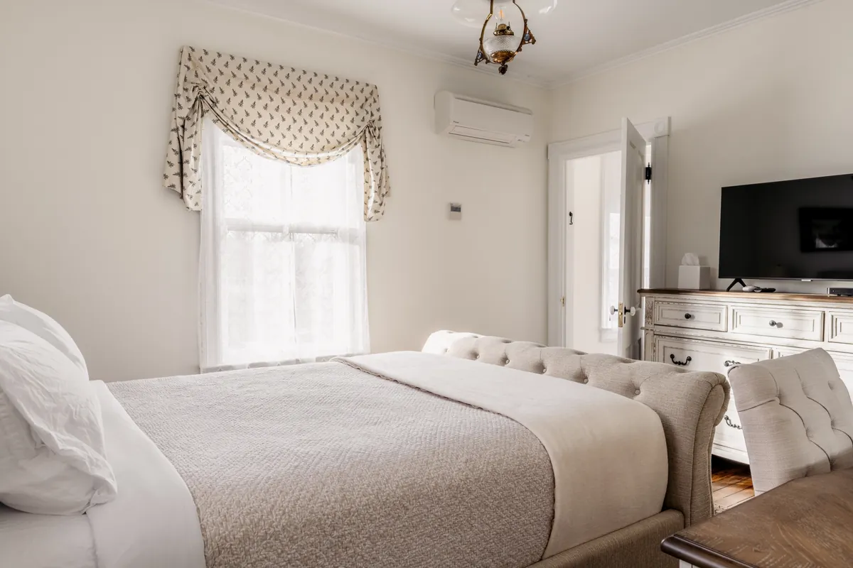 Darwin Room from the bed toward the dresser, wall-mounted TV and window