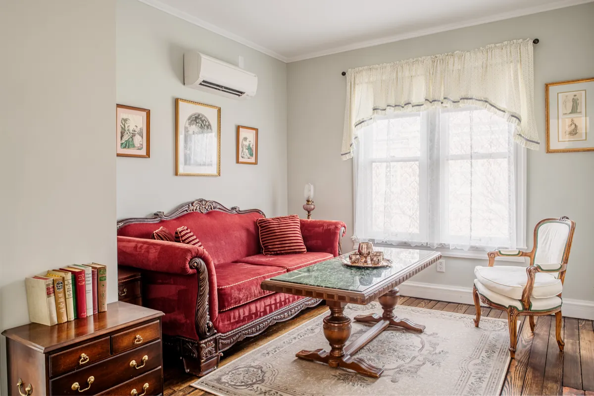 Dickens Suite sitting room with red sofa and coffee table