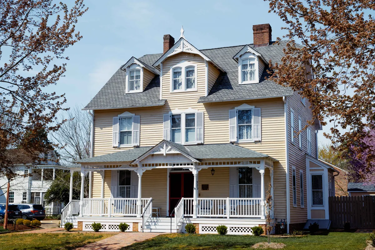 Exterior of Armistead House today at 320 N Henry Street in Williamsburg, Virginia, showing the fully restored 1890 Queen Anne Victorian facade with wraparound porch and period landscaping